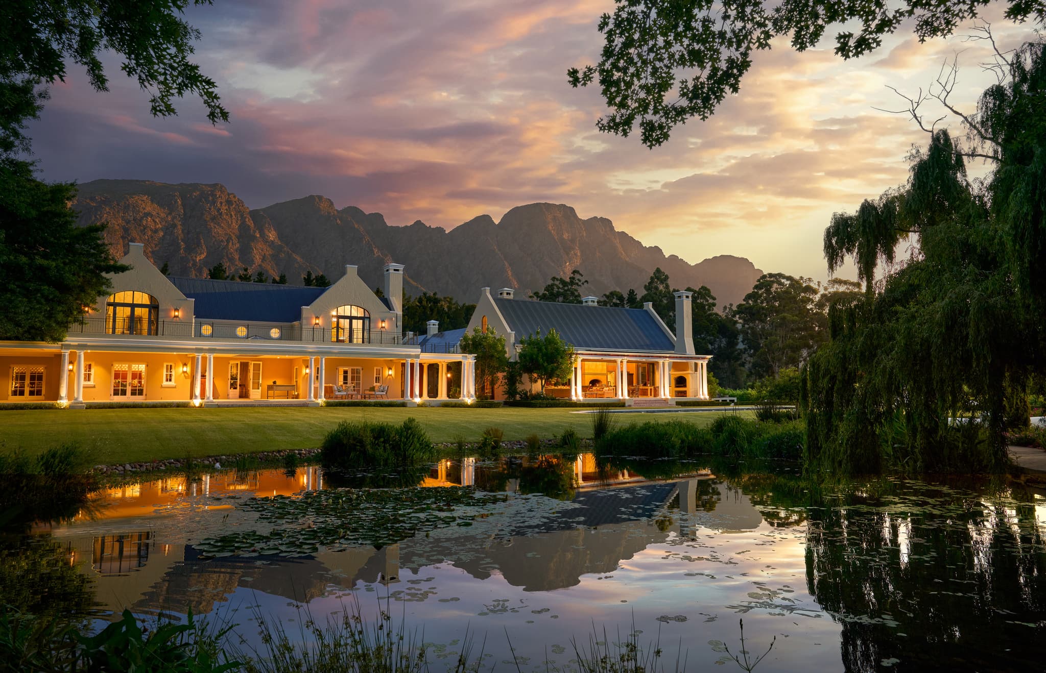The manor house at dusk, reflected in the pond